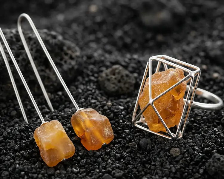 Unique raw amber specimen anchored in a structural silver frame, showcasing natural crust and inclusions, set against a dark architectural background.